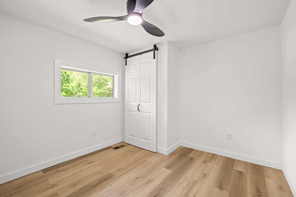 514 Ash Loop Road Blue Ridge, GA 30513 - Photo 20 of 24 an empty room with wooden floor fan and windows