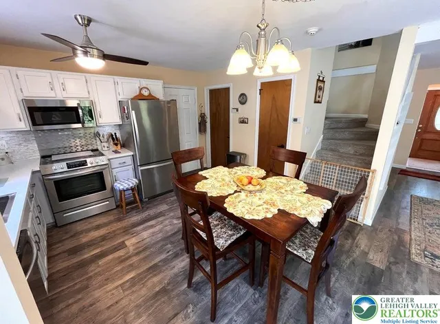 a kitchen with stainless steel appliances kitchen island granite countertop a table chairs and stove