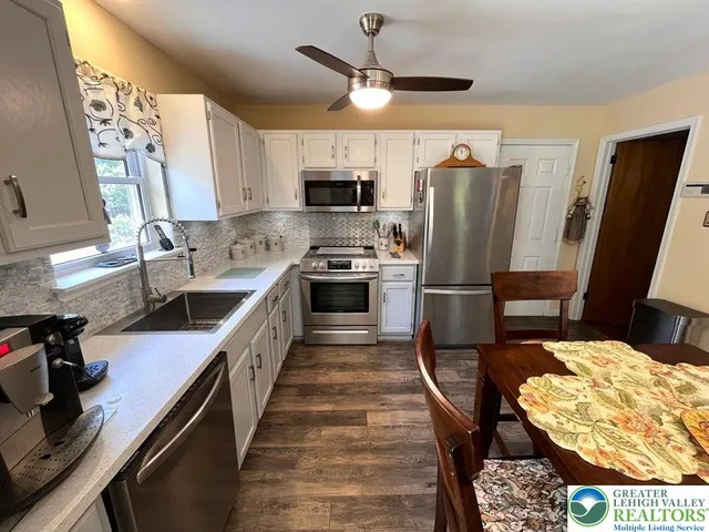 a kitchen with stainless steel appliances granite countertop a sink a stove and a refrigerator