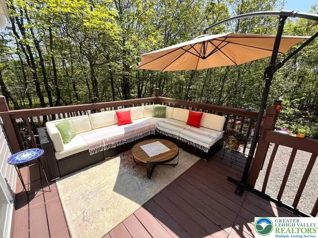 an outdoor sitting area with furniture and wooden floor