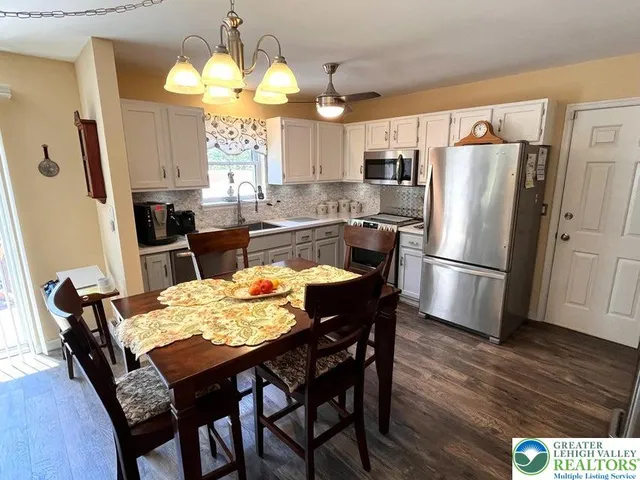 a kitchen with stainless steel appliances granite countertop a dining table and chairs