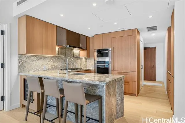 a kitchen with kitchen island a refrigerator stove microwave and cabinets