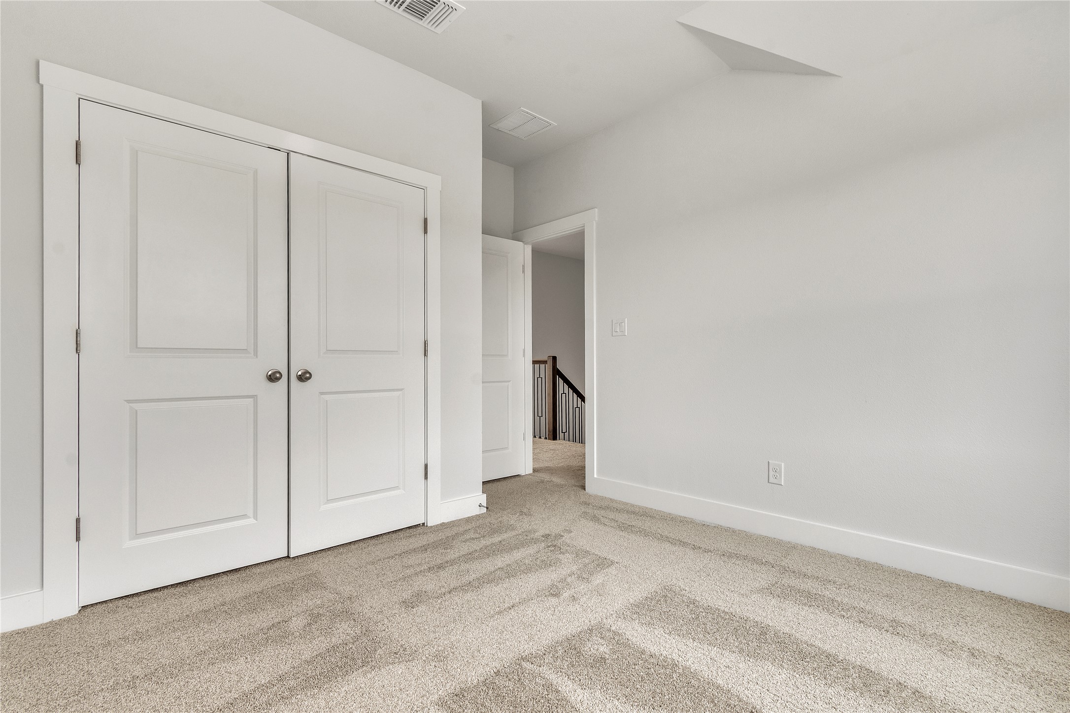 8500 Red Bottle Brush Road Lago Vista, TX 78645 - Photo 26 of 33 A quiet secondary bedroom features twin closets, soft carpet flooring, and access to a central staircase.