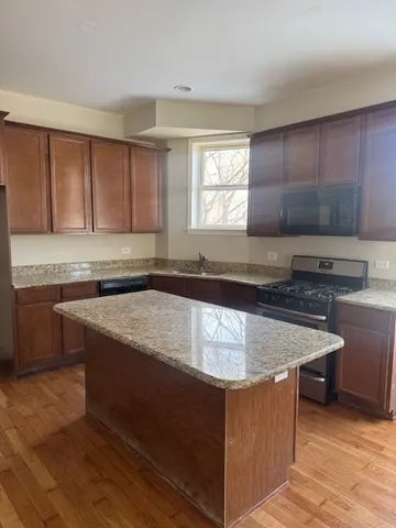 an empty room with wooden floor and windows with curtains