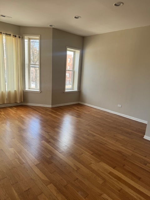 6418-20 South Stewart Avenue Chicago, IL 60621 - Photo 23 of 41 an empty room with wooden floor and windows with curtains view