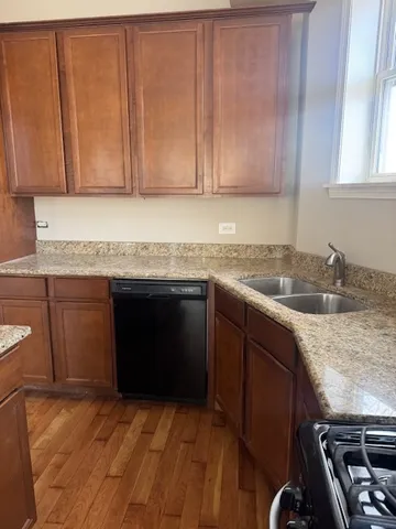 a kitchen with granite countertop a sink stove and cabinets