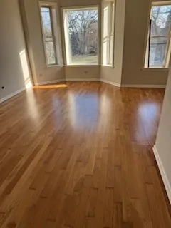a view of a hallway with wooden floor and stairs