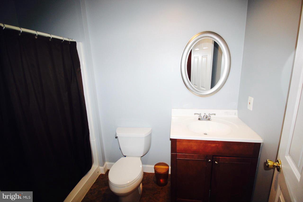 1322 North Rolling Road Baltimore, MD 21228 - Photo 20 of 30 a bathroom with a toilet a sink and a mirror