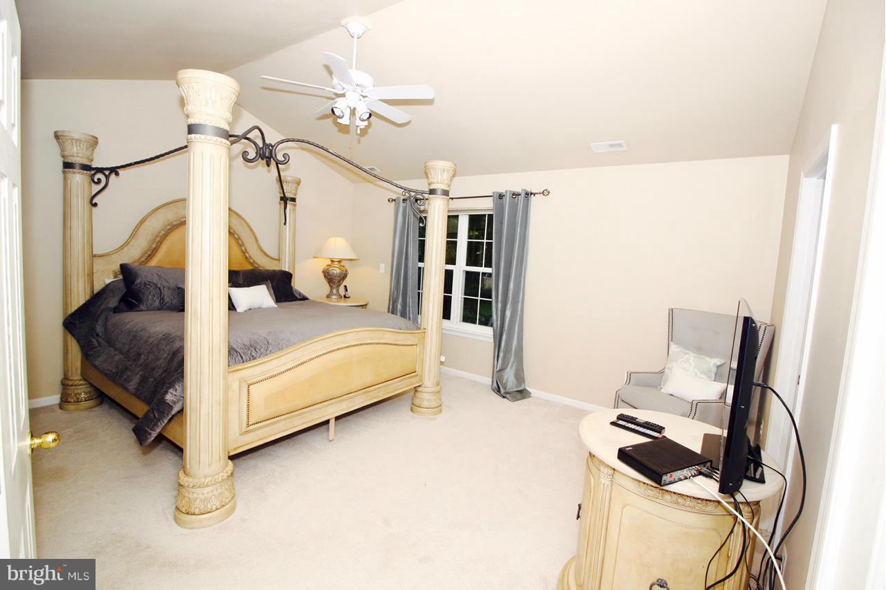 1322 North Rolling Road Baltimore, MD 21228 - Photo 22 of 30 a spacious bedroom with a bed and a chandelier