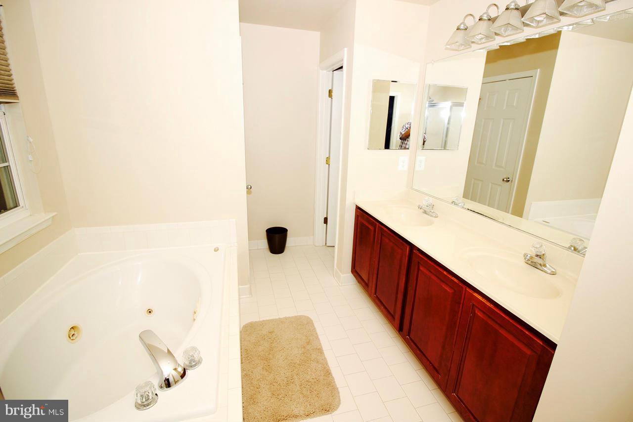 1322 North Rolling Road Baltimore, MD 21228 - Photo 23 of 30 a spacious bathroom with a tub sink and mirror
