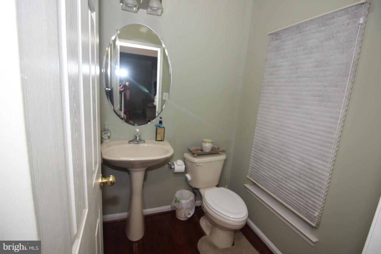 1322 North Rolling Road Baltimore, MD 21228 - Photo 9 of 30 a bathroom with a toilet sink and mirror