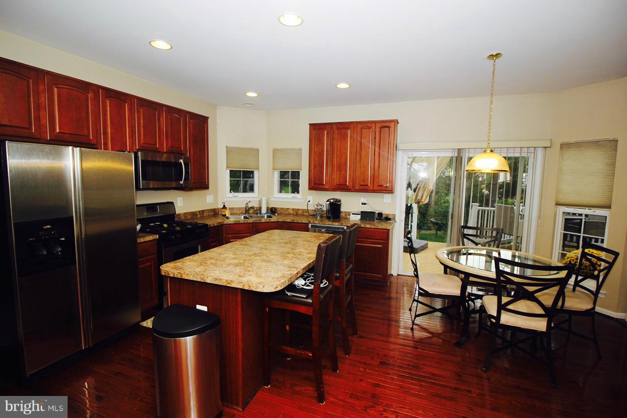 1322 North Rolling Road Baltimore, MD 21228 - Photo 10 of 30 a kitchen with stainless steel appliances granite countertop a refrigerator a table and chairs
