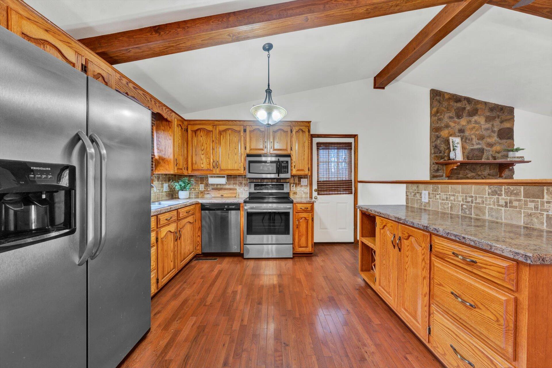 2921 Quarles Road Thaxton, VA 24174 - Photo 10 of 30 a kitchen with stainless steel appliances wooden floor sink and wooden cabinets