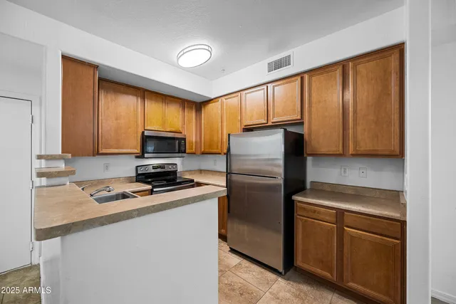 a kitchen with granite countertop cabinets stainless steel appliances and a window
