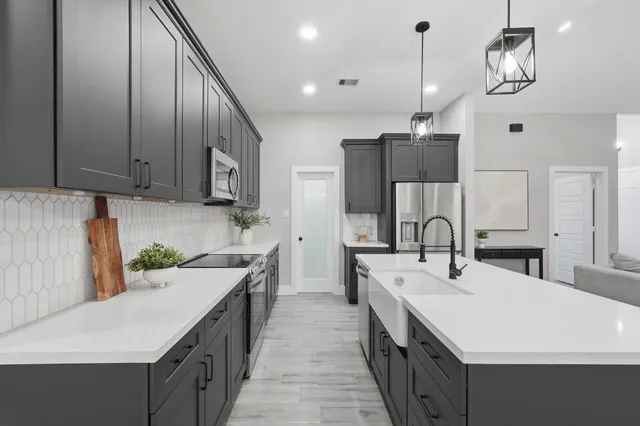 a kitchen with stainless steel appliances a sink stove and refrigerator