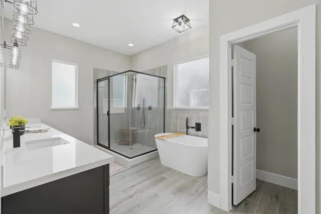 a spacious bathroom with a double vanity sink a large mirror and a bathtub