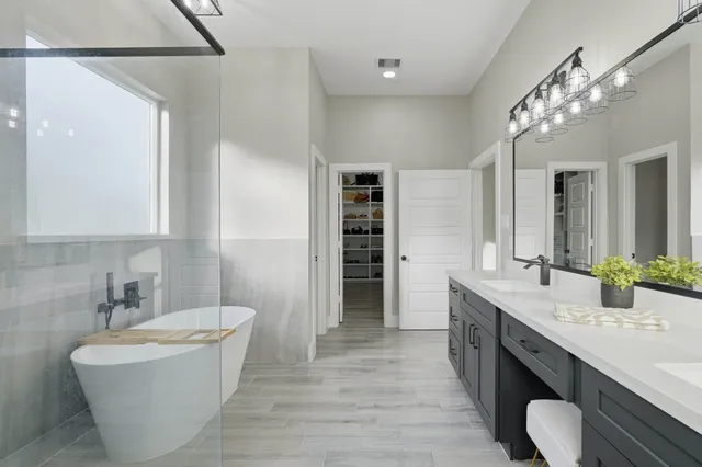 a bathroom with a white bath tub a shower and sink