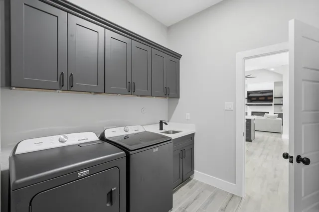 a room with white cabinets and wooden floor