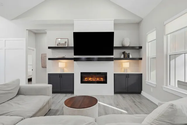 a living room with furniture a flat screen tv and a fireplace