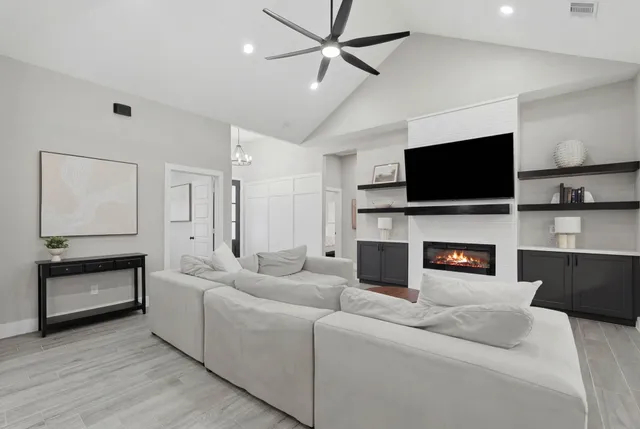 a living room with furniture a fireplace and a flat screen tv