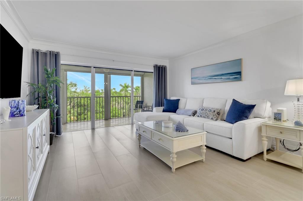 1 Bluebill Avenue, Unit 410 Naples, FL 34108 - Photo 1 of 36 a living room with furniture and a flat screen tv