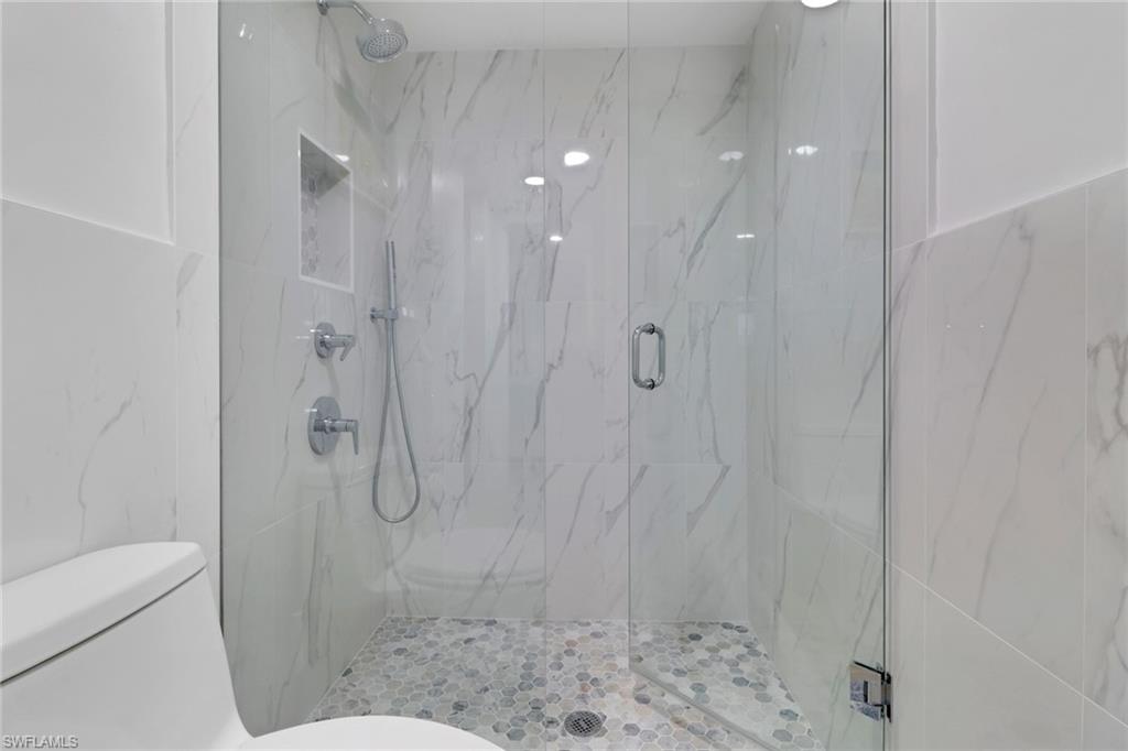 1 Bluebill Avenue, Unit 410 Naples, FL 34108 - Photo 14 of 36 a bathroom with a shower and a toilet