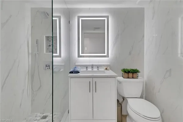 a bathroom with a sink a toilet and shower