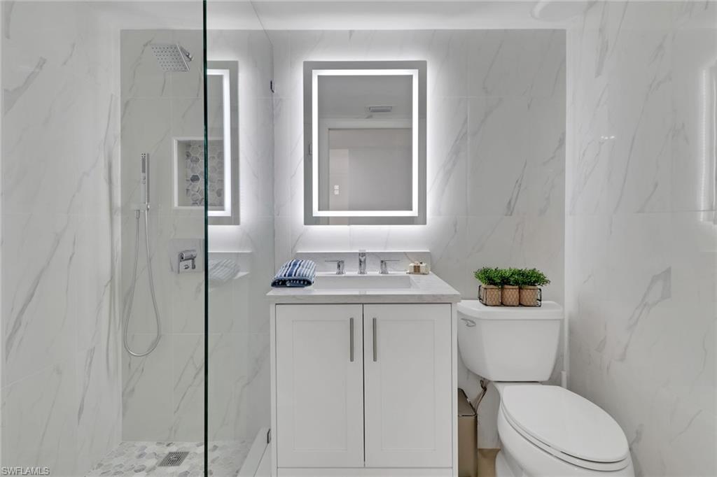 1 Bluebill Avenue, Unit 410 Naples, FL 34108 - Photo 18 of 36 a bathroom with a sink a toilet and shower