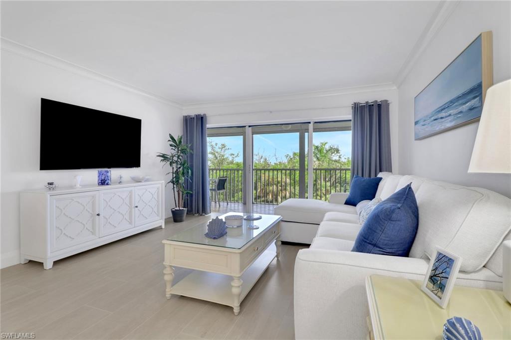 1 Bluebill Avenue, Unit 410 Naples, FL 34108 - Photo 2 of 36 a living room with furniture and a flat screen tv
