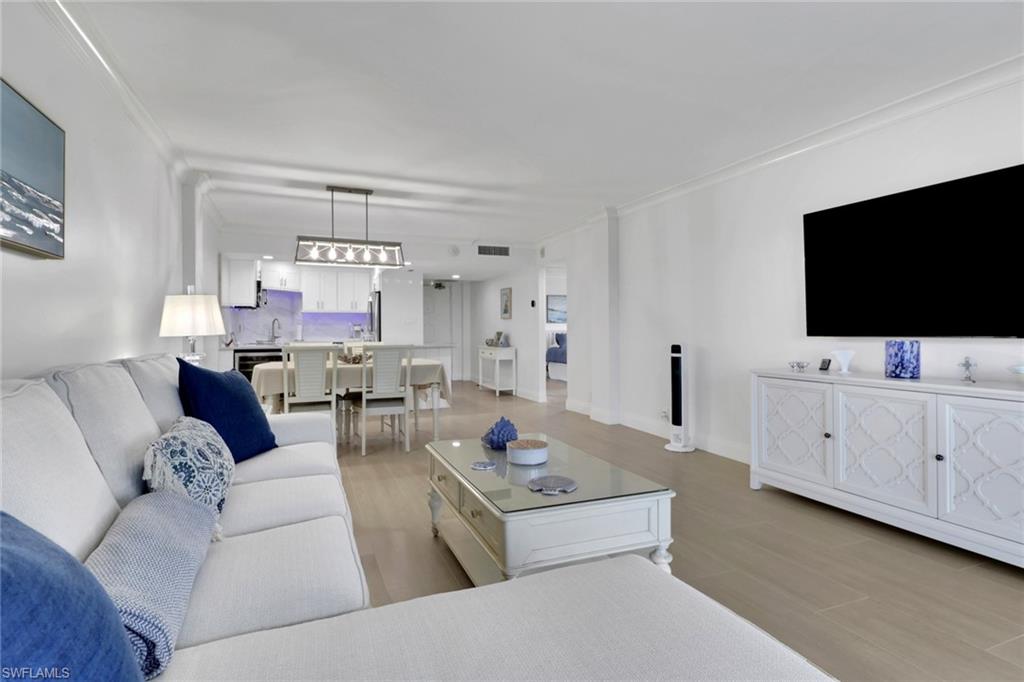 1 Bluebill Avenue, Unit 410 Naples, FL 34108 - Photo 4 of 36 a living room with furniture and a flat screen tv