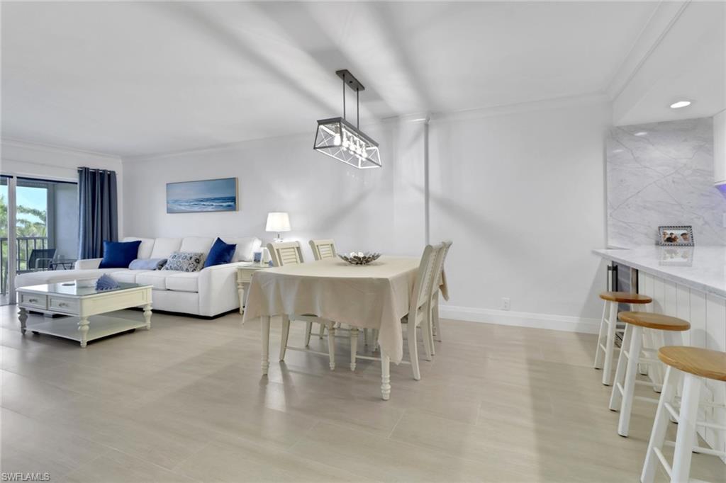 1 Bluebill Avenue, Unit 410 Naples, FL 34108 - Photo 6 of 36 a living room with furniture and a table