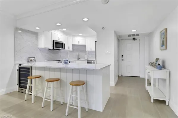 a kitchen with kitchen island cabinets and chairs in it