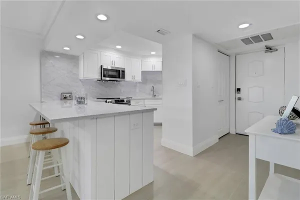 a kitchen with stainless steel appliances granite countertop a sink and a refrigerator