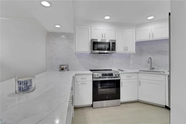 a kitchen with a sink and steel appliances