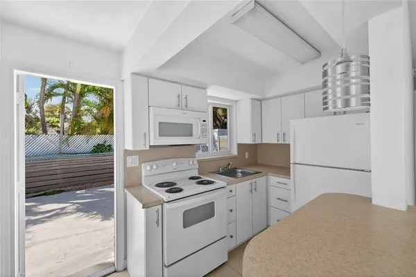 a kitchen with appliances a sink and a refrigerator