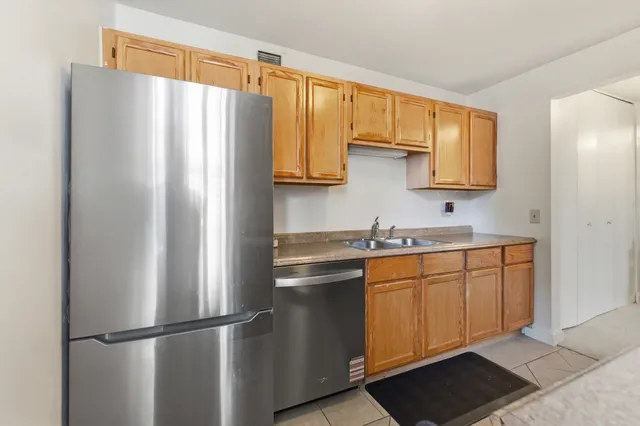 a view of cabinets a center island a wooden floor and a window