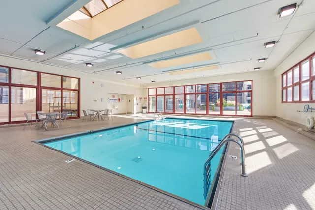 a living room with furniture a flat screen tv and a refrigerator