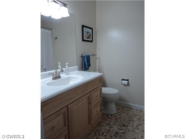 3325 Lancelot Road Petersburg, VA 23805 - Photo 6 of 12 a bathroom with a toilet a sink and mirror