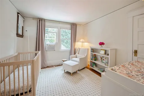 a living room with furniture and a baby crib