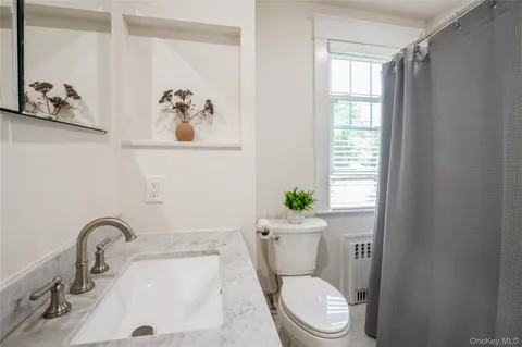 a white toilet sitting next to a bathroom sink