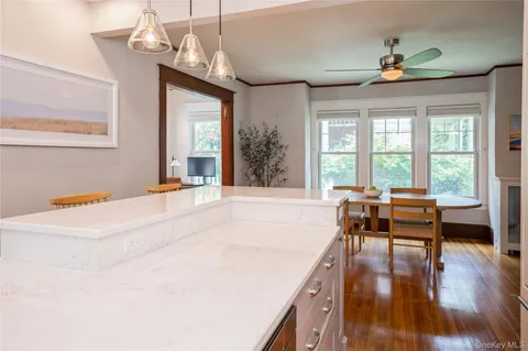 a dining room with wooden floor a chandelier a wooden table and chairs