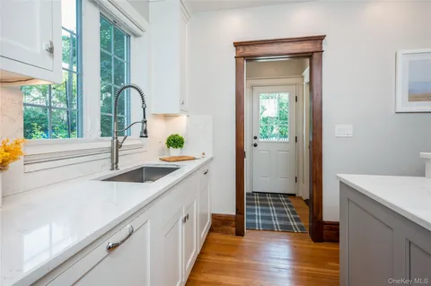 a kitchen with a sink and wooden floor