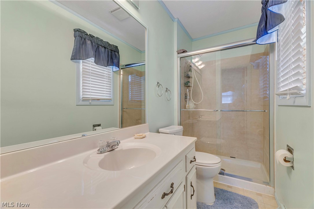 563 North Carpenter Road Brunswick, OH 44212 - Photo 23 of 45 Bathroom with vanity, a stall shower, light tile patterned floors, and crown molding
