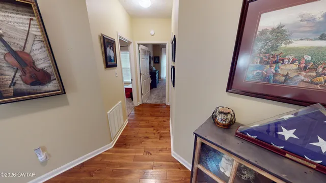 a hallway with painting on the wall and a window