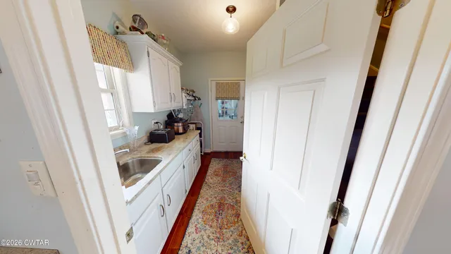 a walk in closet with wooden floor