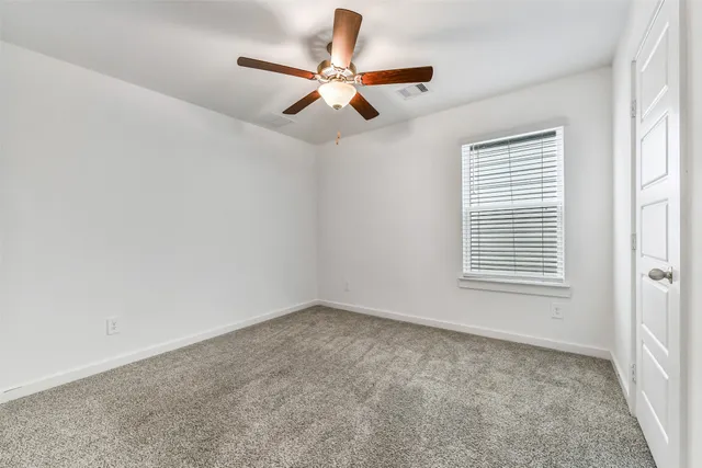 an empty room with fan and a ceiling fan