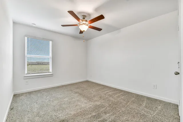 an empty room with fan and windows