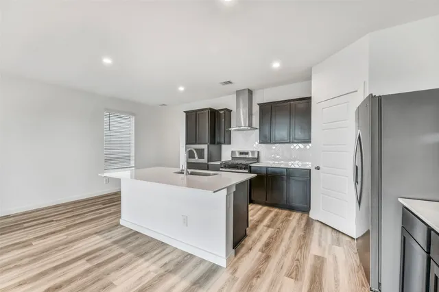 a kitchen with stainless steel appliances granite countertop a sink stove and refrigerator