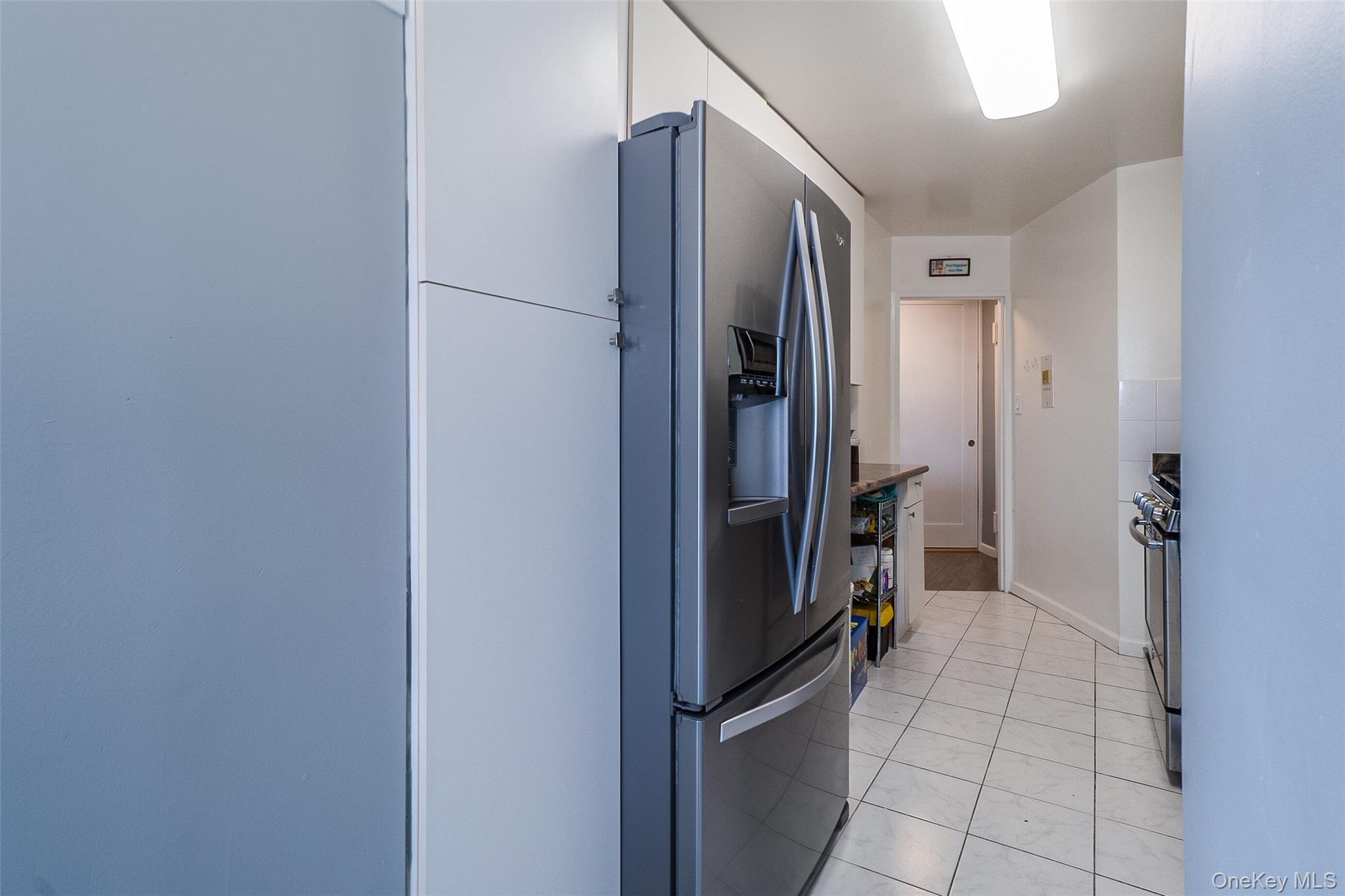 85-15 Main Street, Unit J12 Queens, NY 11435 - Photo 14 of 26 a view of a refrigerator in kitchen and an empty room