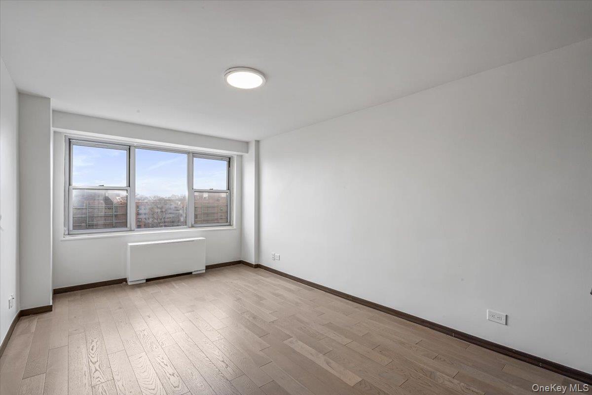 85-15 Main Street, Unit J12 Queens, NY 11435 - Photo 15 of 26 an empty room with wooden floor and windows